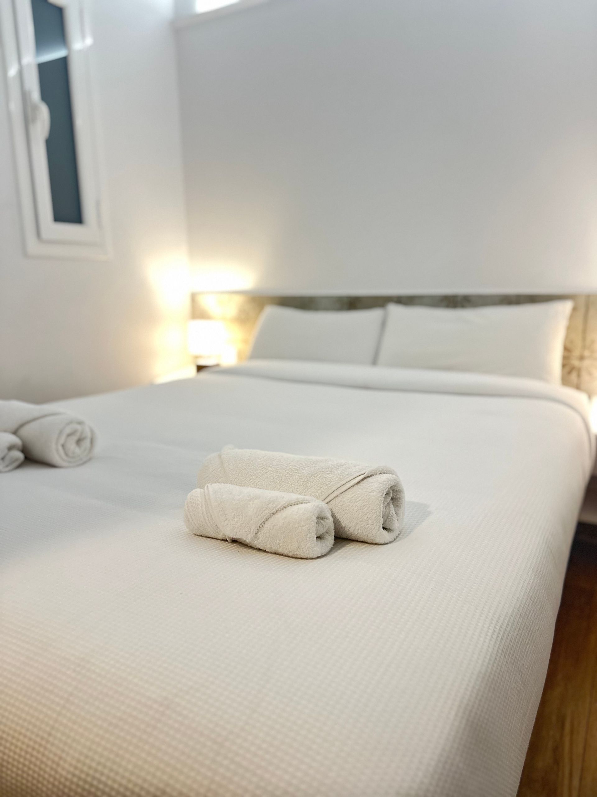 Cama de Airbnb preparada con toallas tras limpieza profesional para mejorar puntuación de limpieza